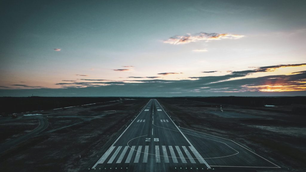 Airport runway stretching toward the horizon at sunset
