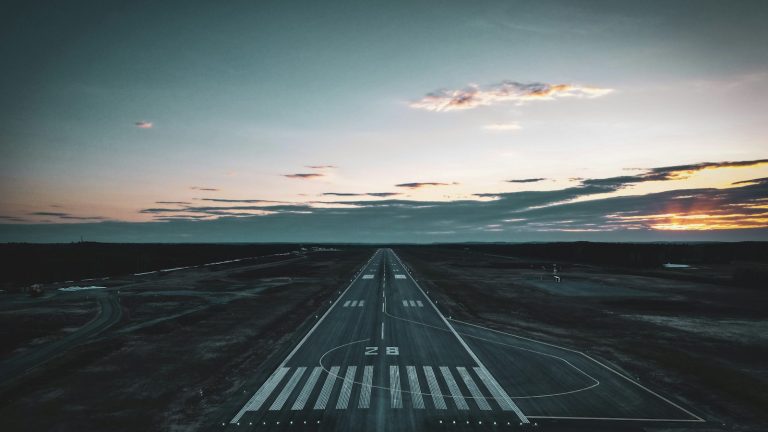 Airport runway stretching toward the horizon at sunset
