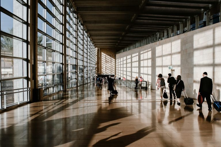 Travellers walking through an airport concourse with luggage