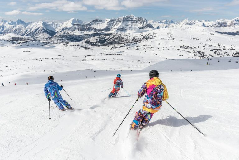 Three skiers descend a snow-covered mountain.
