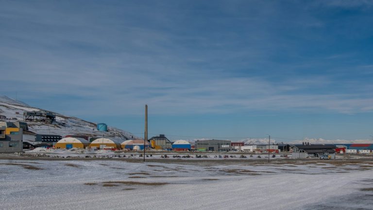Snowy industrial buildings in an Arctic landscape — illustrative