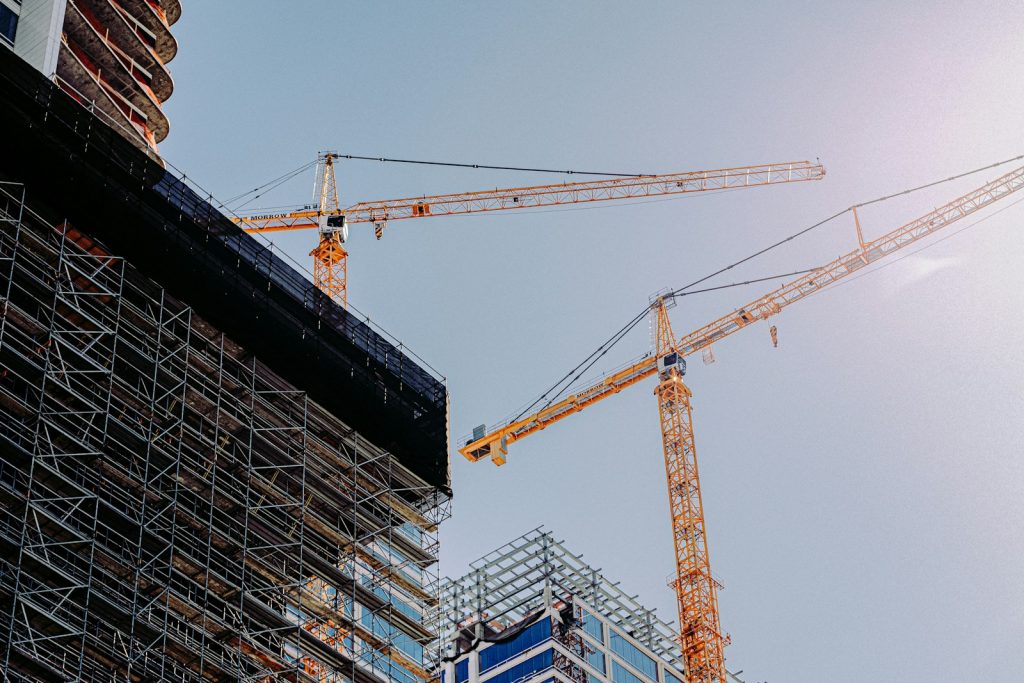 Tower cranes beside a multi-storey building under construction