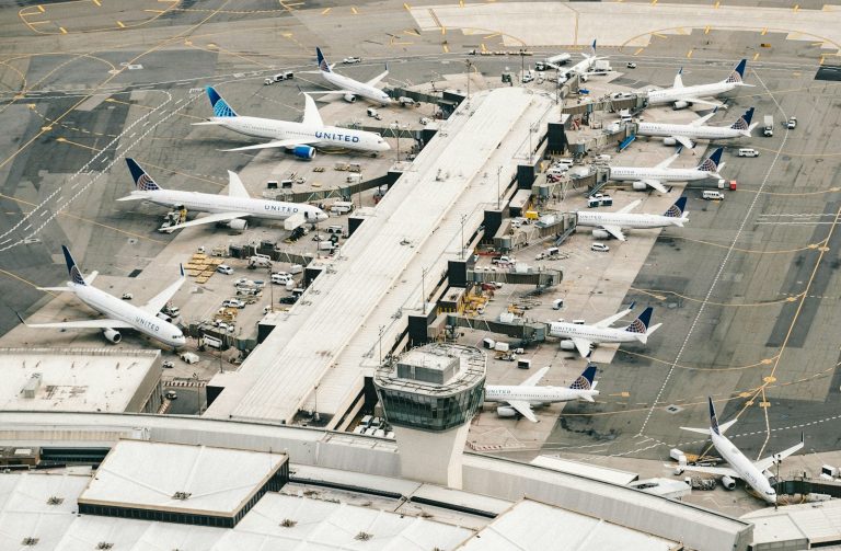 Aerial view of passenger aircraft parked around an airport terminal