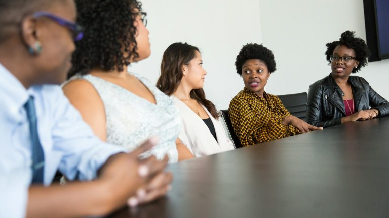 Five people taking part in a meeting around a table