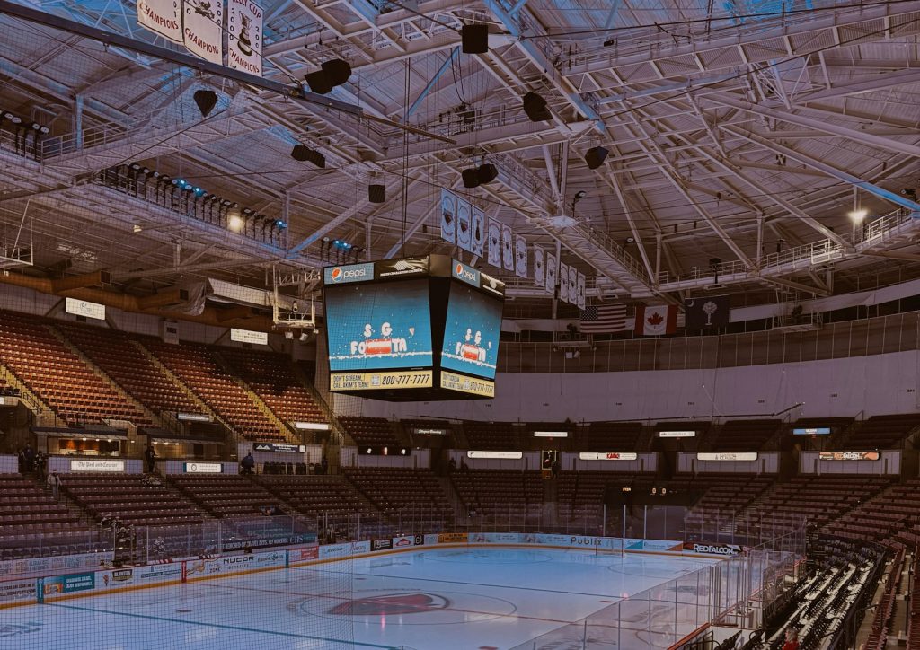 Empty indoor ice arena with rink, seating and scoreboard