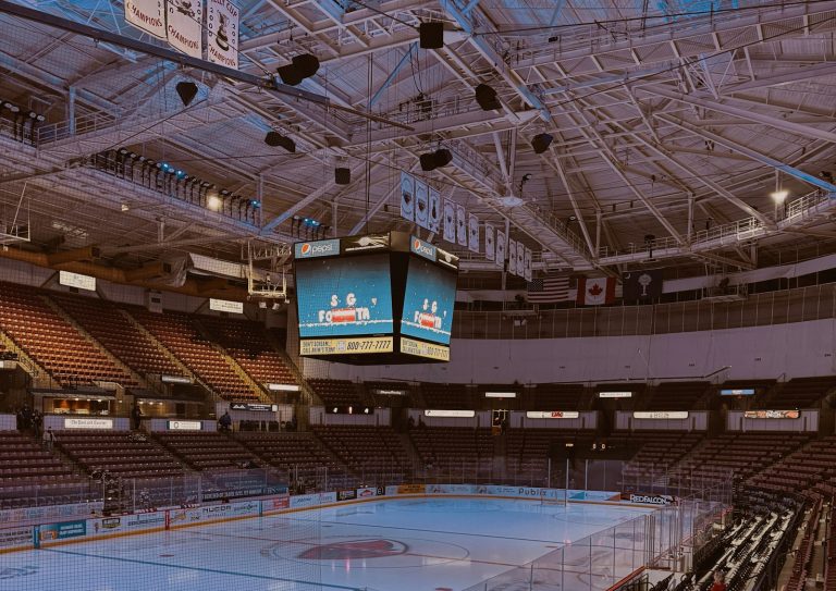 Empty indoor ice arena with rink, seating and scoreboard