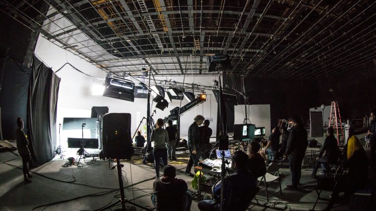 Film crew and production equipment inside a studio