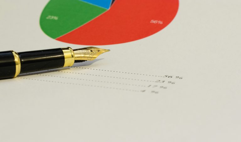 Fountain pen beside a printed pie chart and percentages