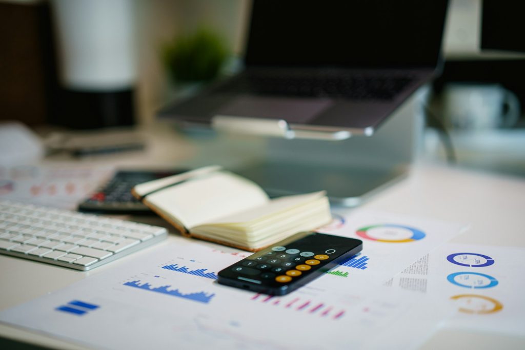 Calculator, charts and notebook on a desk
