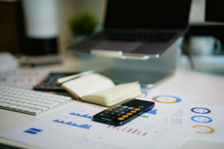 Calculator, charts and notebook on a desk