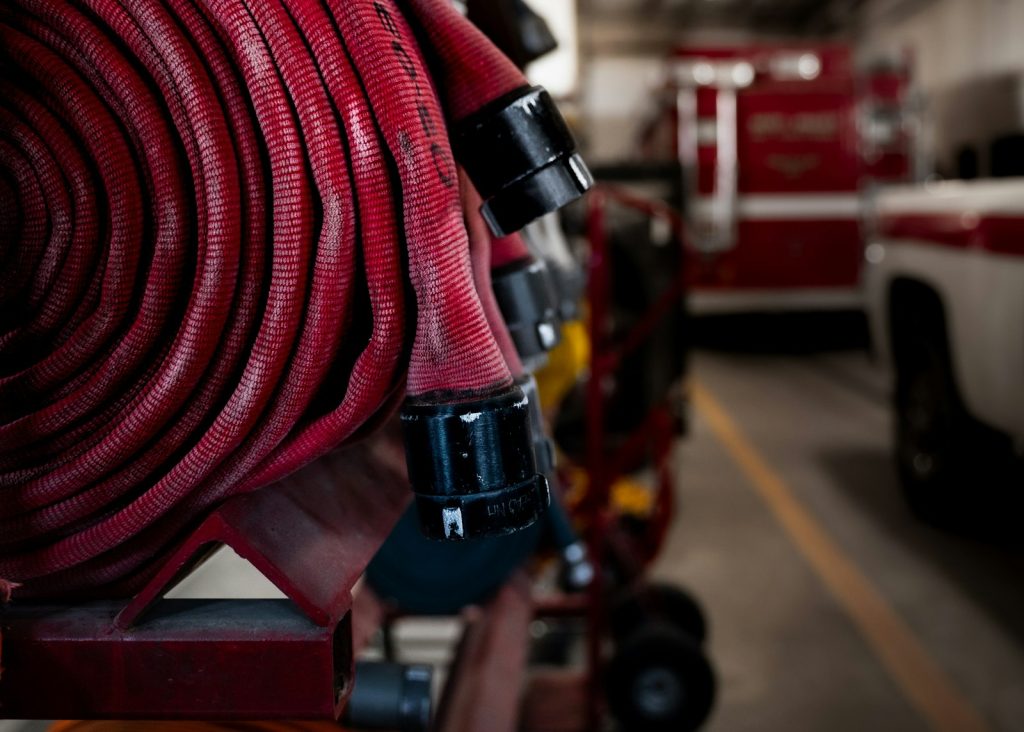 A coiled fire hose mounted beside a fire truck.