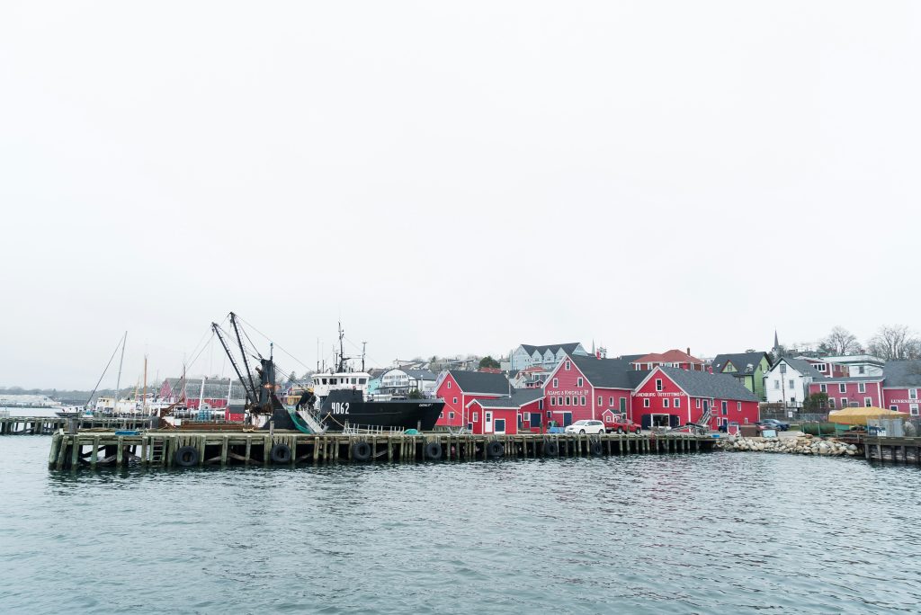 Fishing boat and colourful waterfront buildings in an Atlantic Canadian harbour, illustrative stock image.