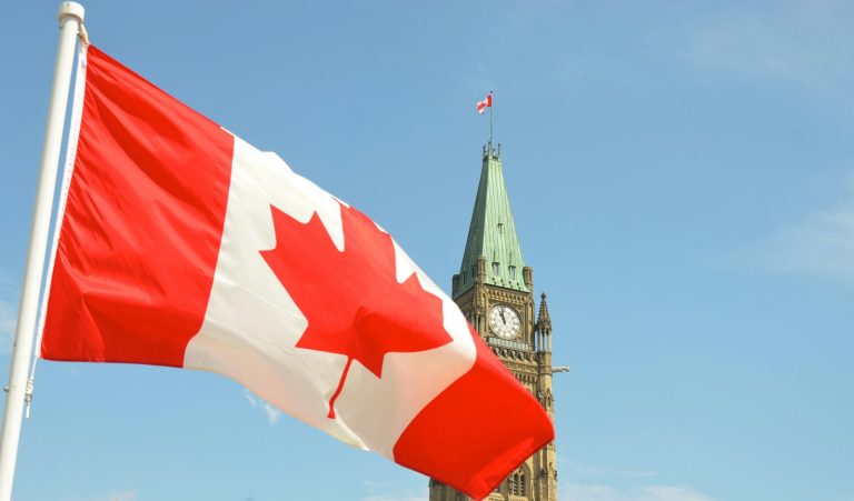 Canadian flag waving in front of the Peace Tower on Parliament Hill