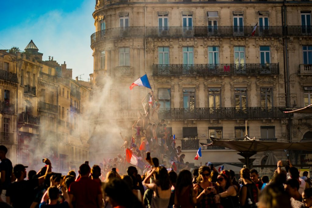 Crowd gathered in a city square with French flags