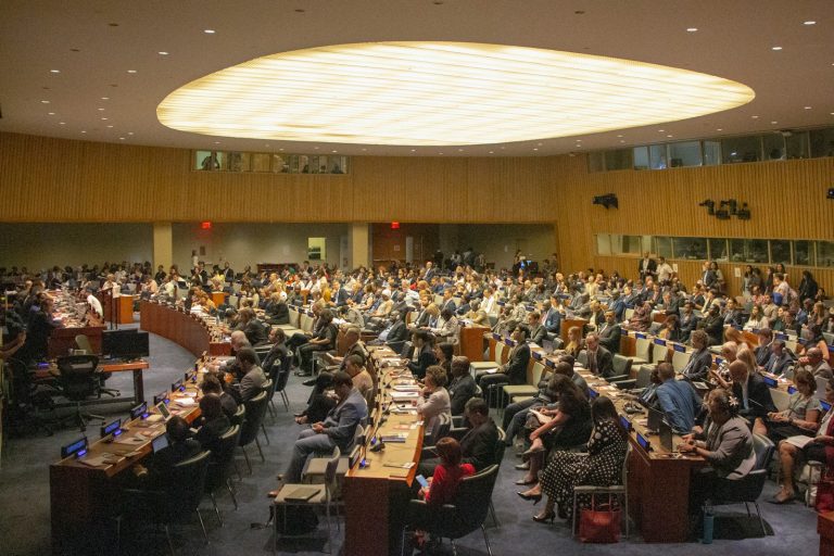 Delegates seated in a large United Nations conference hall, illustrative stock image