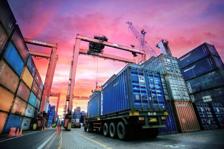 Illustrative cargo containers and truck at a port terminal