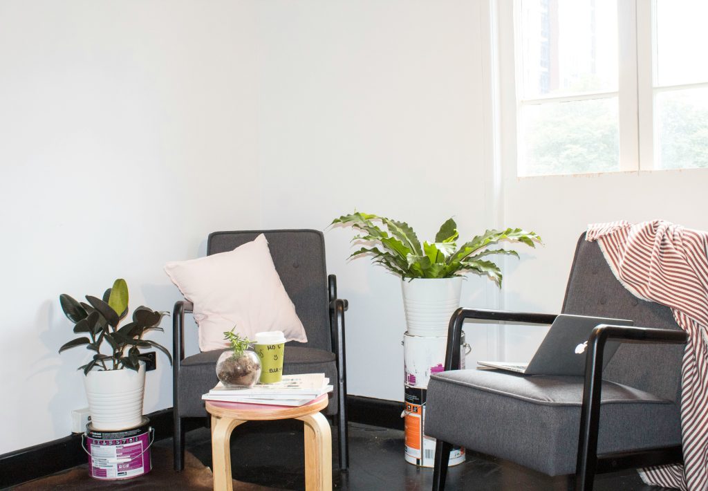 Two chairs and plants in a quiet office, illustrative stock image.