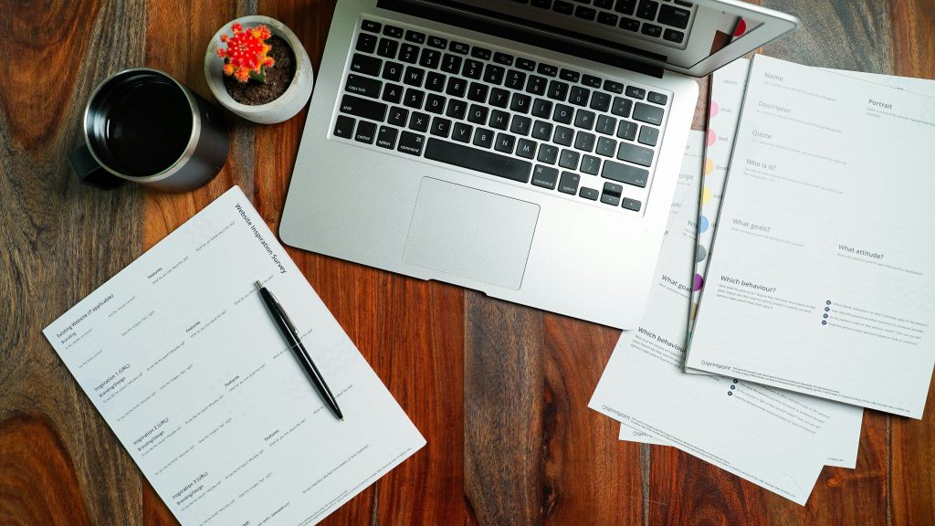 Illustrative laptop and paperwork on a wooden desk