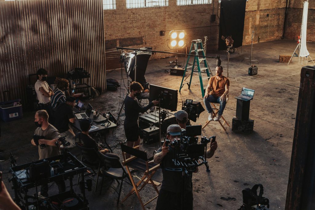 Film crew and cameras working on an indoor production set, illustrative stock image.