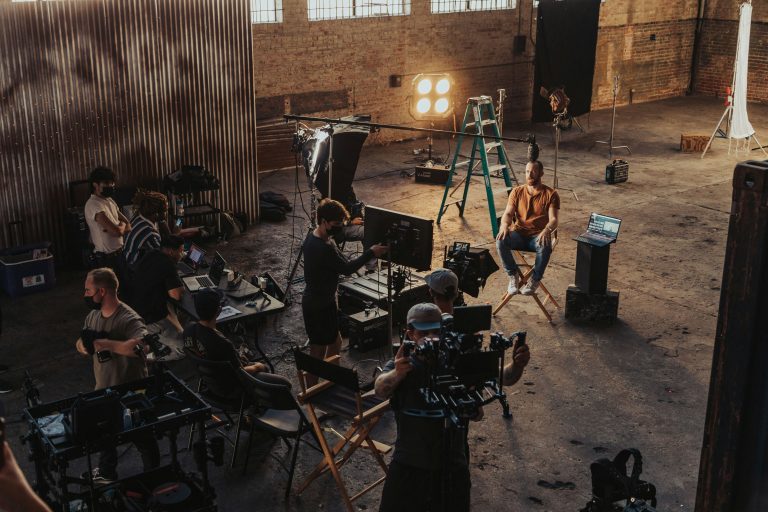 Film crew and cameras working on an indoor production set, illustrative stock image.
