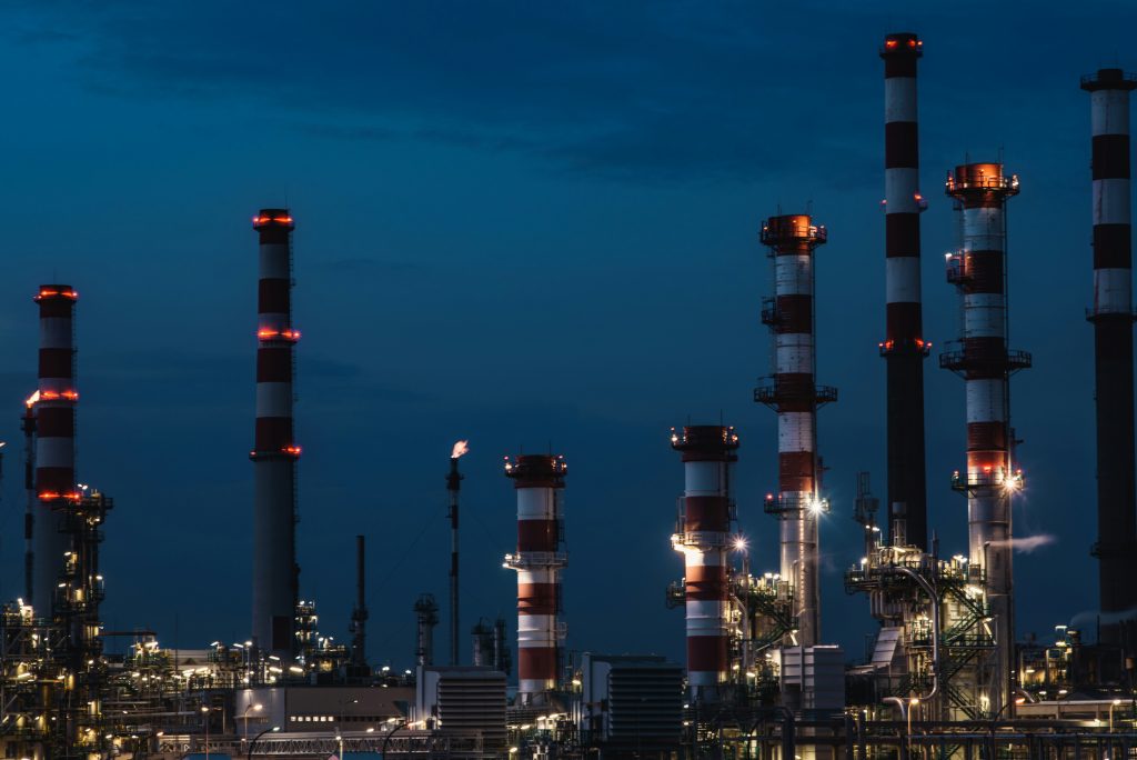 Illustrative industrial refinery towers at dusk