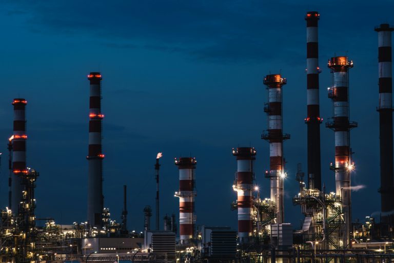 Illustrative industrial refinery towers at dusk