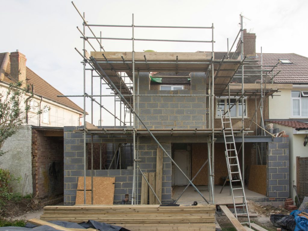Illustrative house under construction with scaffolding