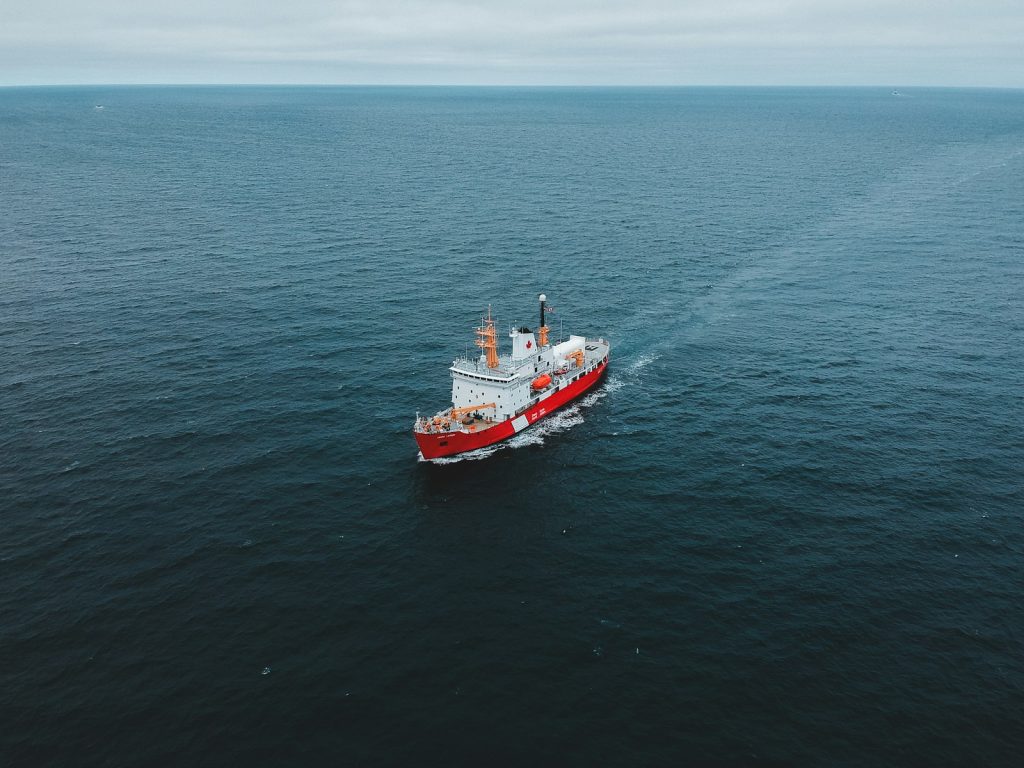 Red and white patrol ship travelling across open ocean