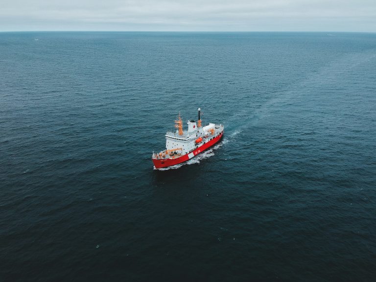 Red and white patrol ship travelling across open ocean