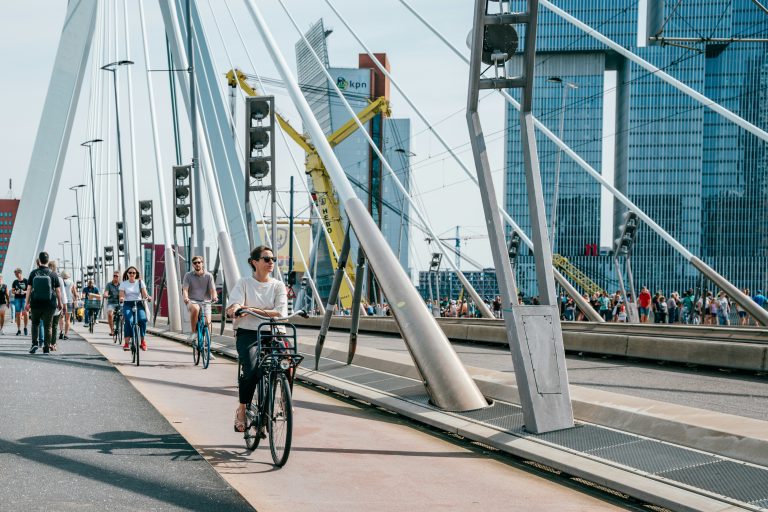 People walking and cycling on a modern bridge, illustrative stock image.