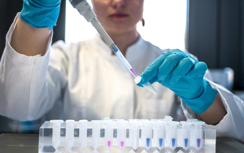 Laboratory scientist using a pipette with sample tubes