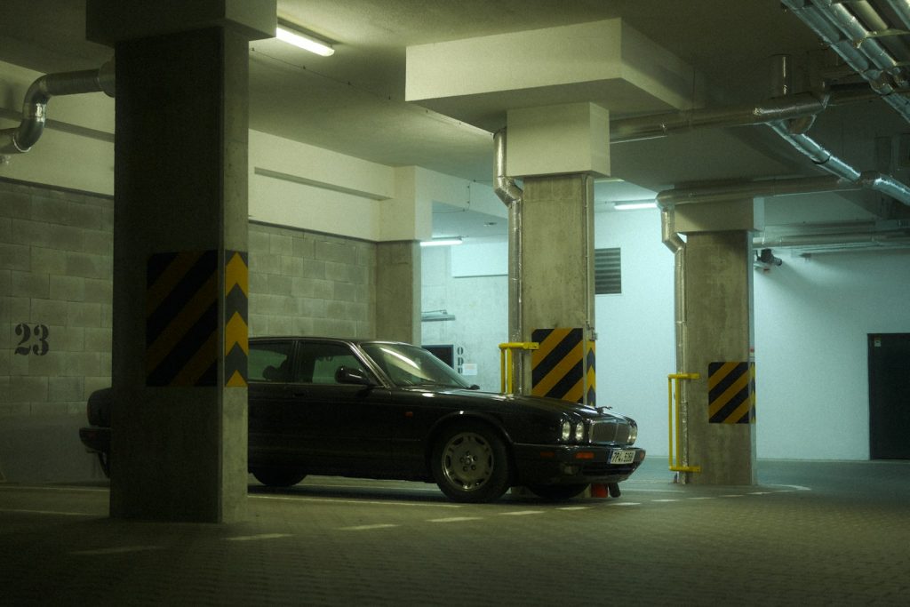 Black sedan parked in an underground garage