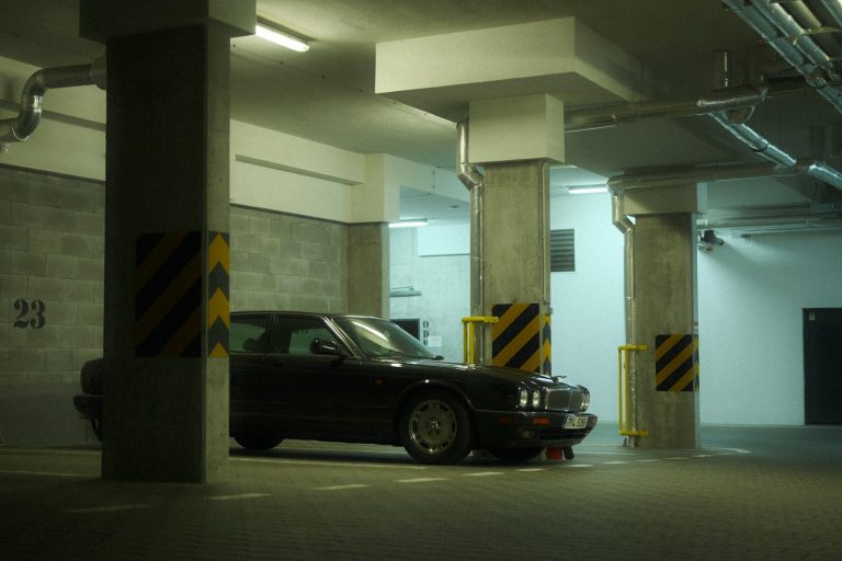 Black sedan parked in an underground garage