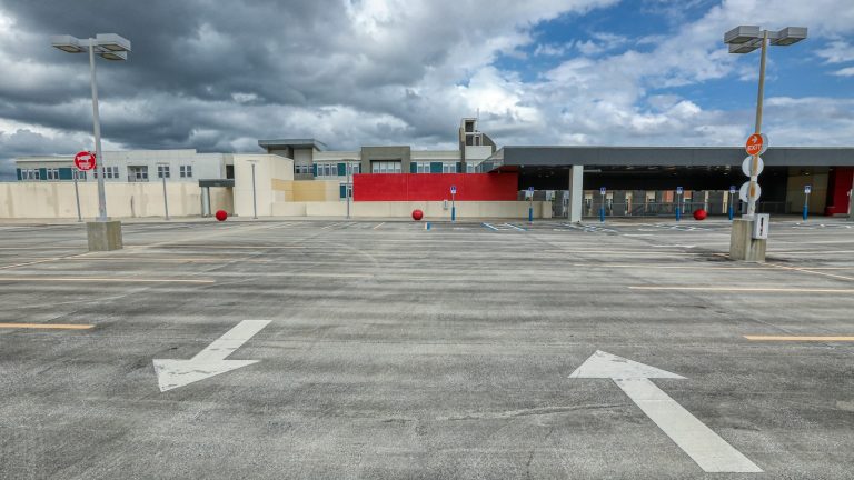 An almost-empty paved parking lot beneath dark clouds.