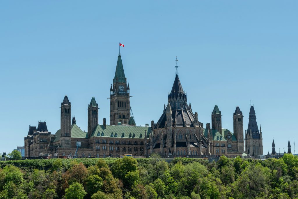 Parliament Hill in Ottawa seen across the Ottawa River under a blue sky