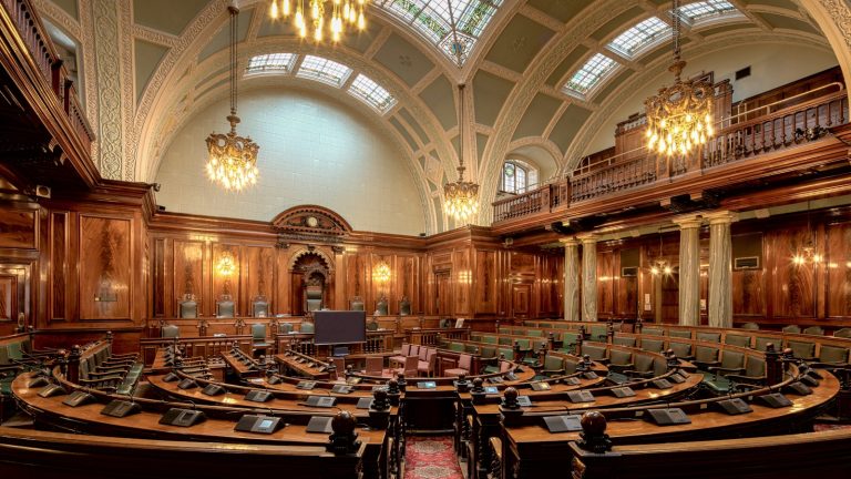 An empty wood-panelled public meeting chamber
