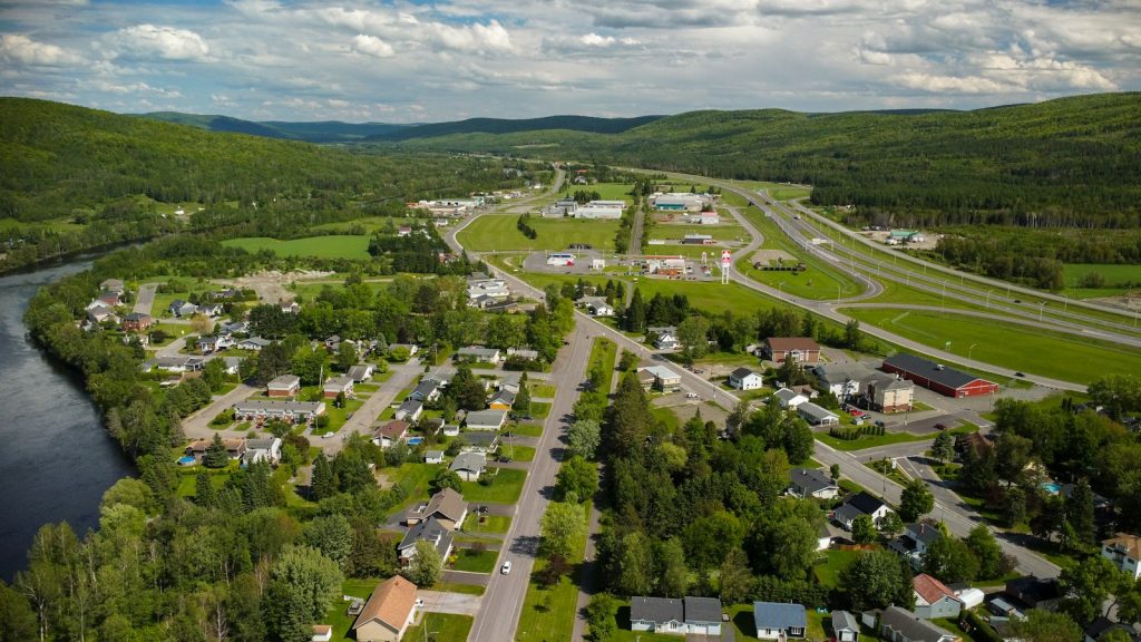 Aerial view of a Québec community with roads, homes, green space and water