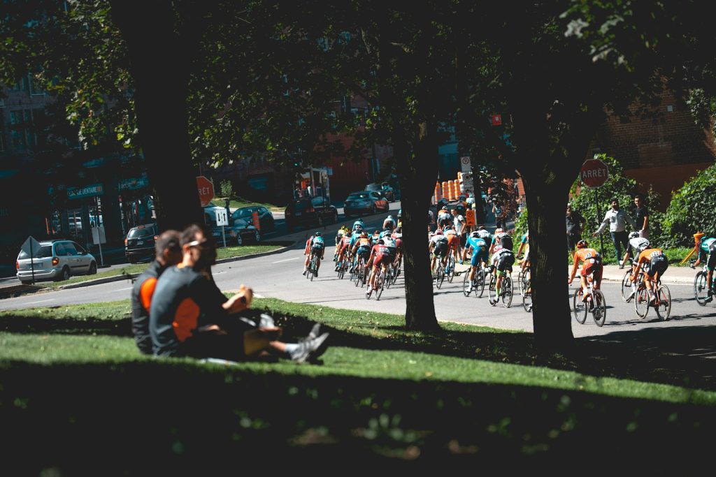 A road-cycling peloton racing along a city street.