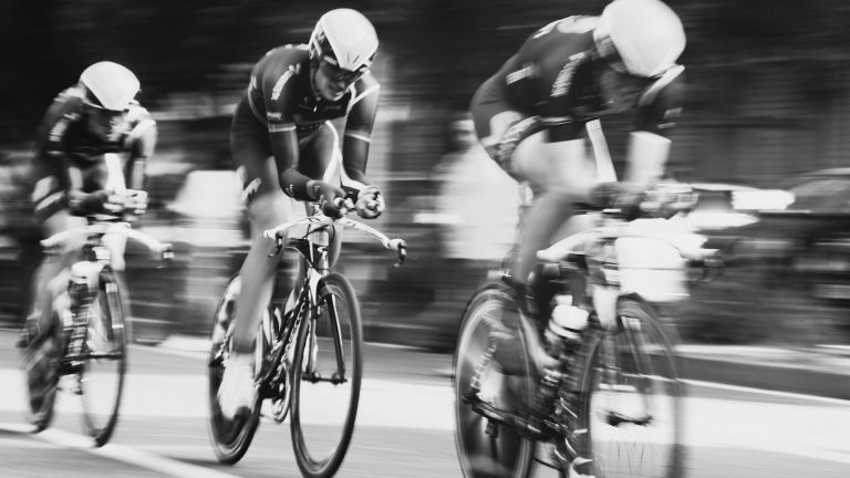 Three road cyclists racing at speed