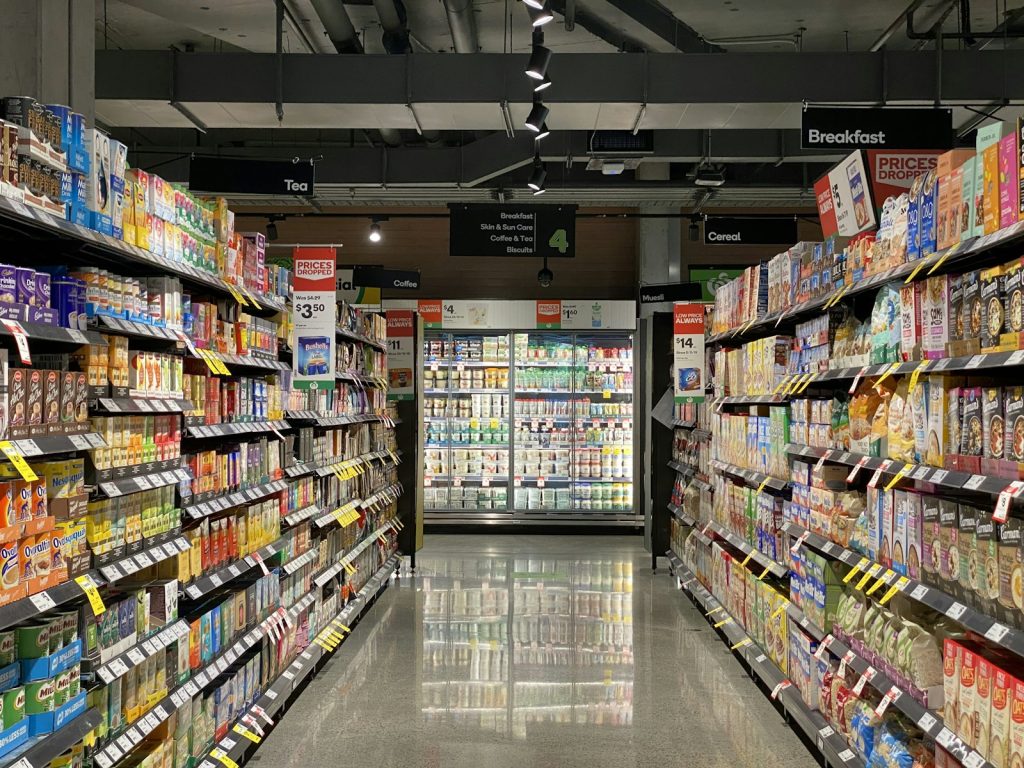 Supermarket aisle lined with packaged food and price labels