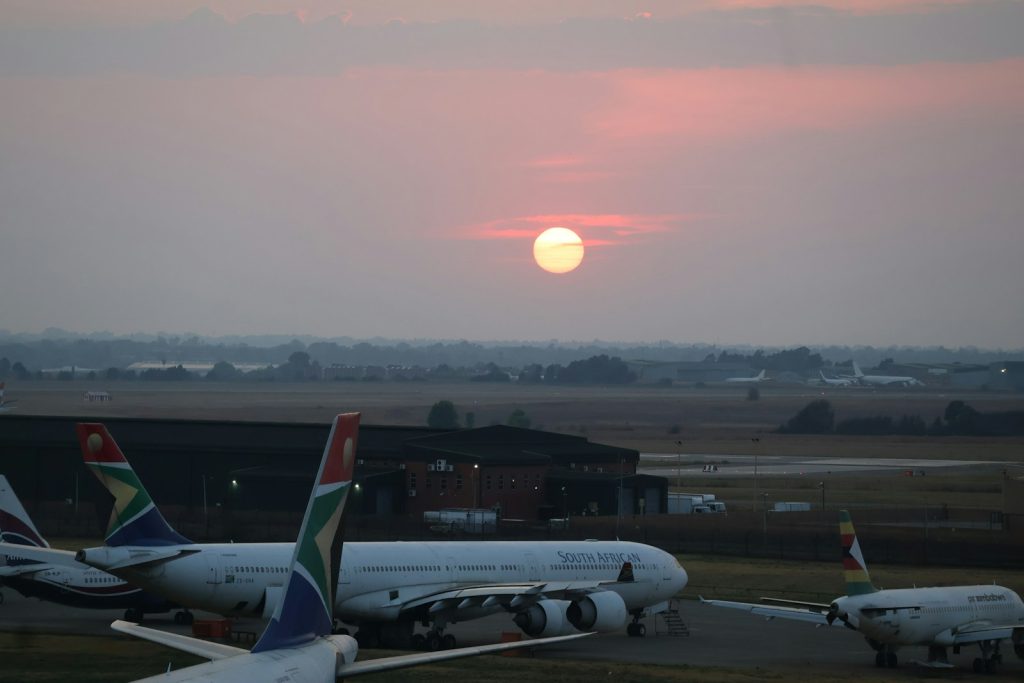 Passenger aircraft parked at O.R. Tambo International Airport at sunrise, illustrative stock image