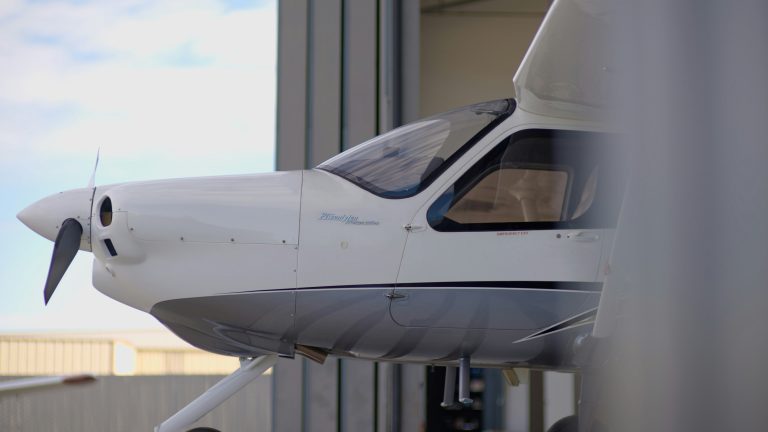 Aircraft parked inside a large maintenance hangar