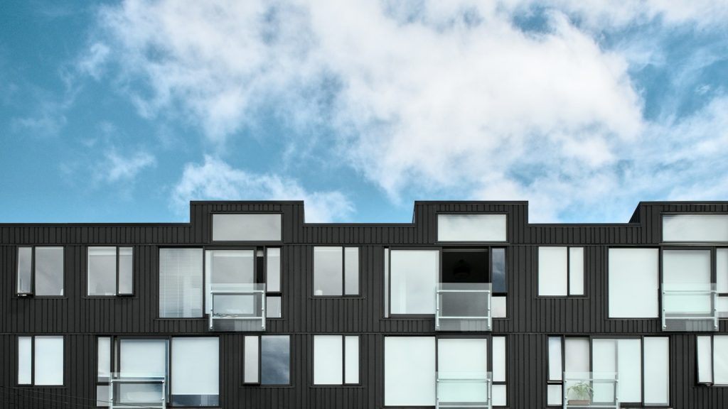 Modern apartment building facade beneath a blue sky