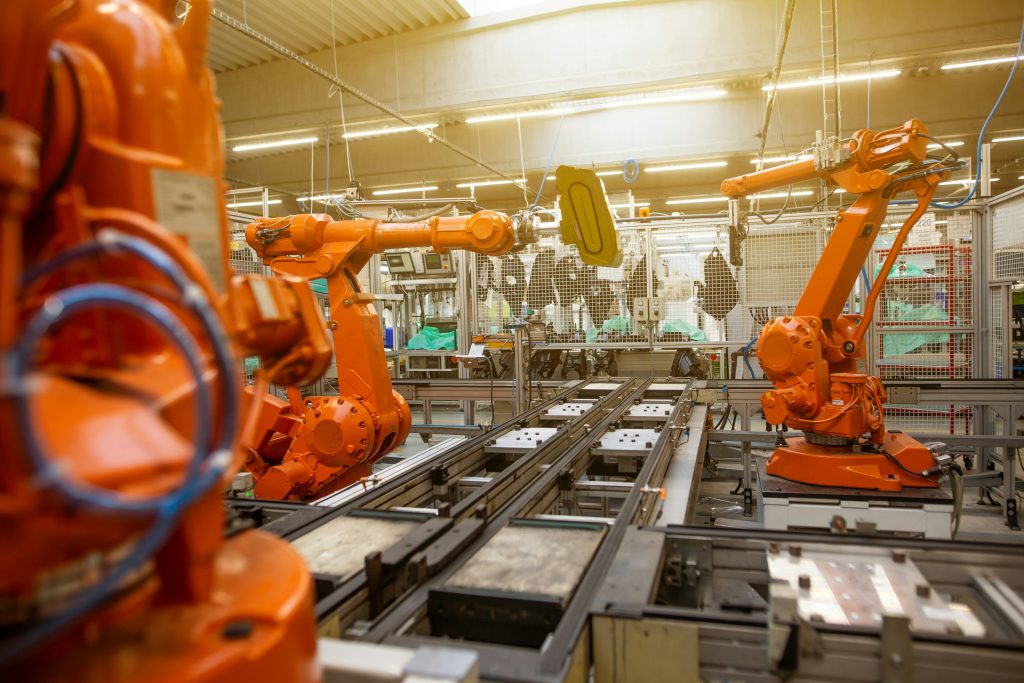 Orange robotic arms operating in an automated factory, used to illustrate Quebec industrial output