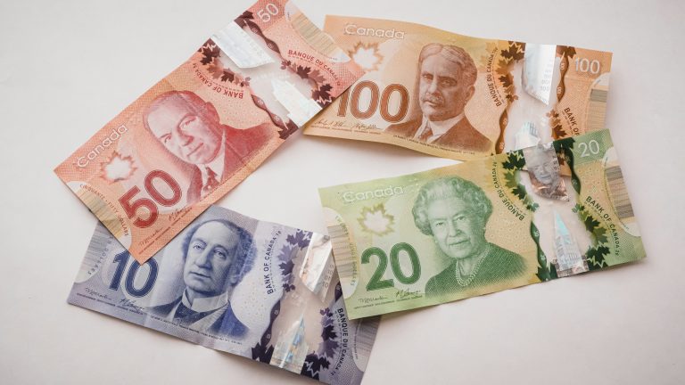 Canadian banknotes arranged on a light surface