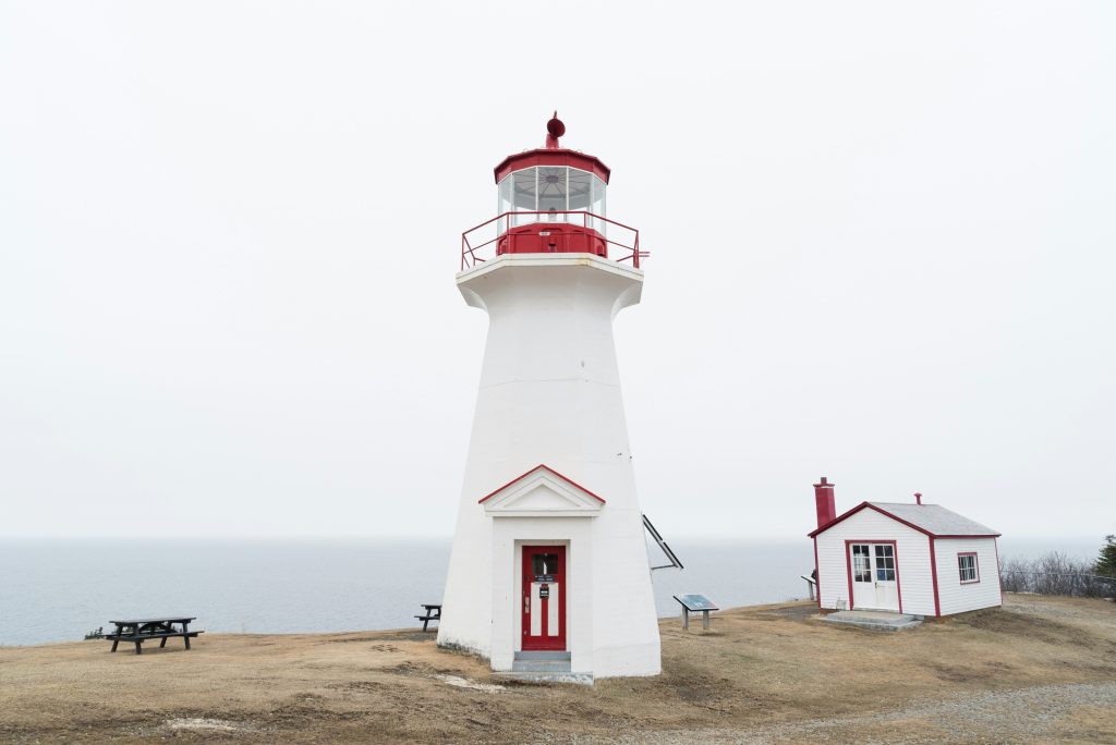 A white and red lighthouse on a Canadian coast, used to illustrate heritage conservation funding