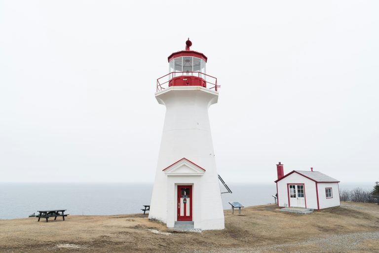 A white and red lighthouse on a Canadian coast, used to illustrate heritage conservation funding