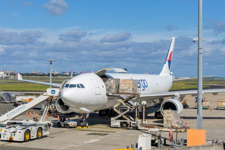 Cargo aircraft being unloaded at an airport, illustrative stock image