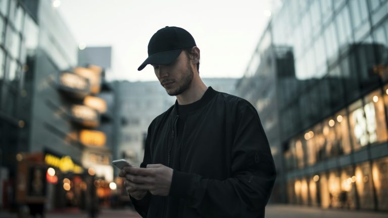 Person using a mobile phone in a city setting, illustrating access to an online citizen portal