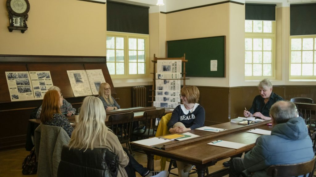 A group of adults seated around tables during a community discussion.